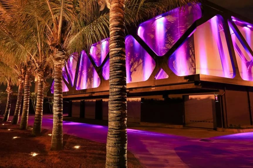 Fachada Lush Ipiranga iluminada em tons de púrpura e âmbar